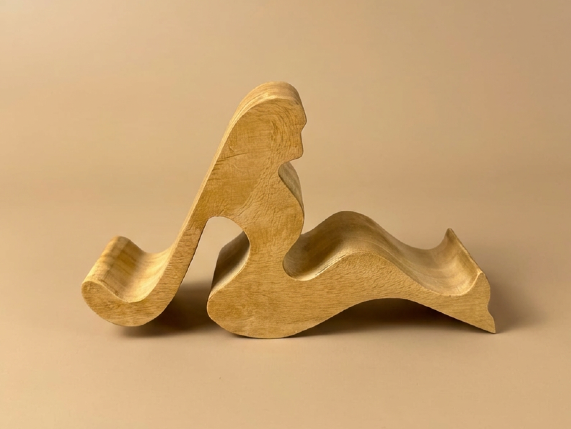 A handcrafted abstract wooden sculpture celebrating feminine form through smooth curves and minimalist design.
