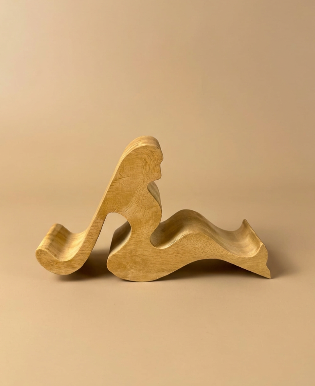A handcrafted abstract wooden sculpture celebrating feminine form through smooth curves and minimalist design.