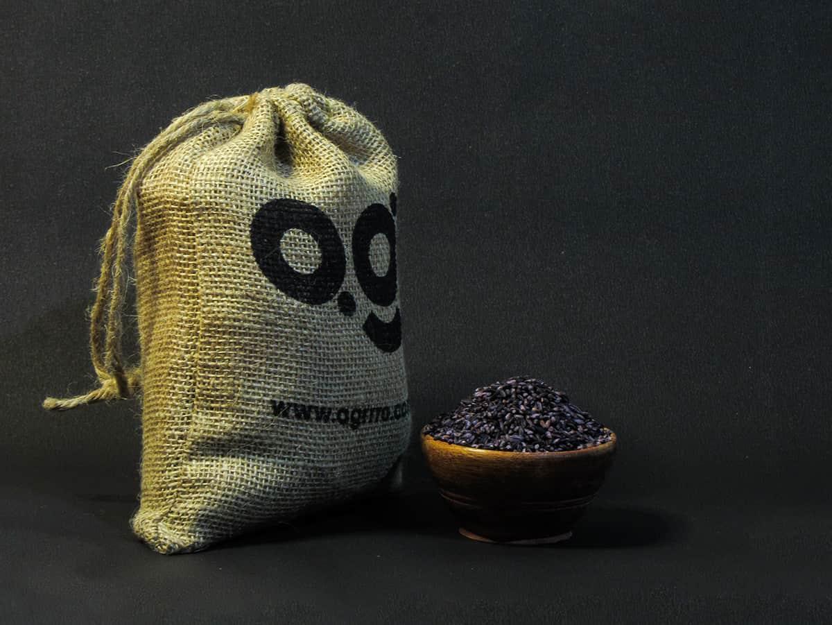 organic black rice also known as purple rice, organic kala chawal, organic rice in a wooden bowl and eco friendly jute packaging on the side filled with organic black rice. Buy best organic black rice in India with plastic free eco friendly packaging now now from agrrro.