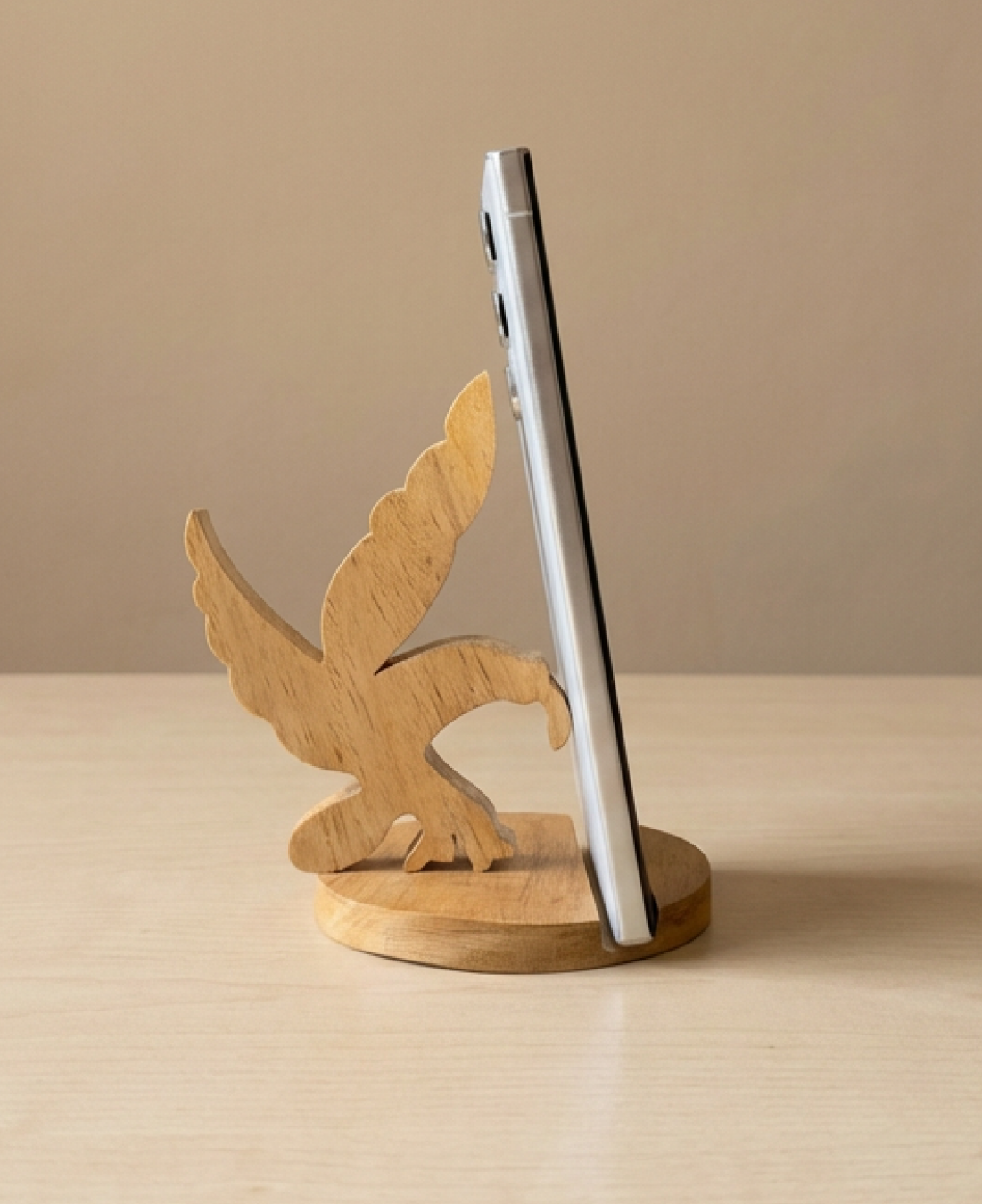 A handcrafted wooden eagle phone stand that offers sturdy phone support with a bold, artistic design.