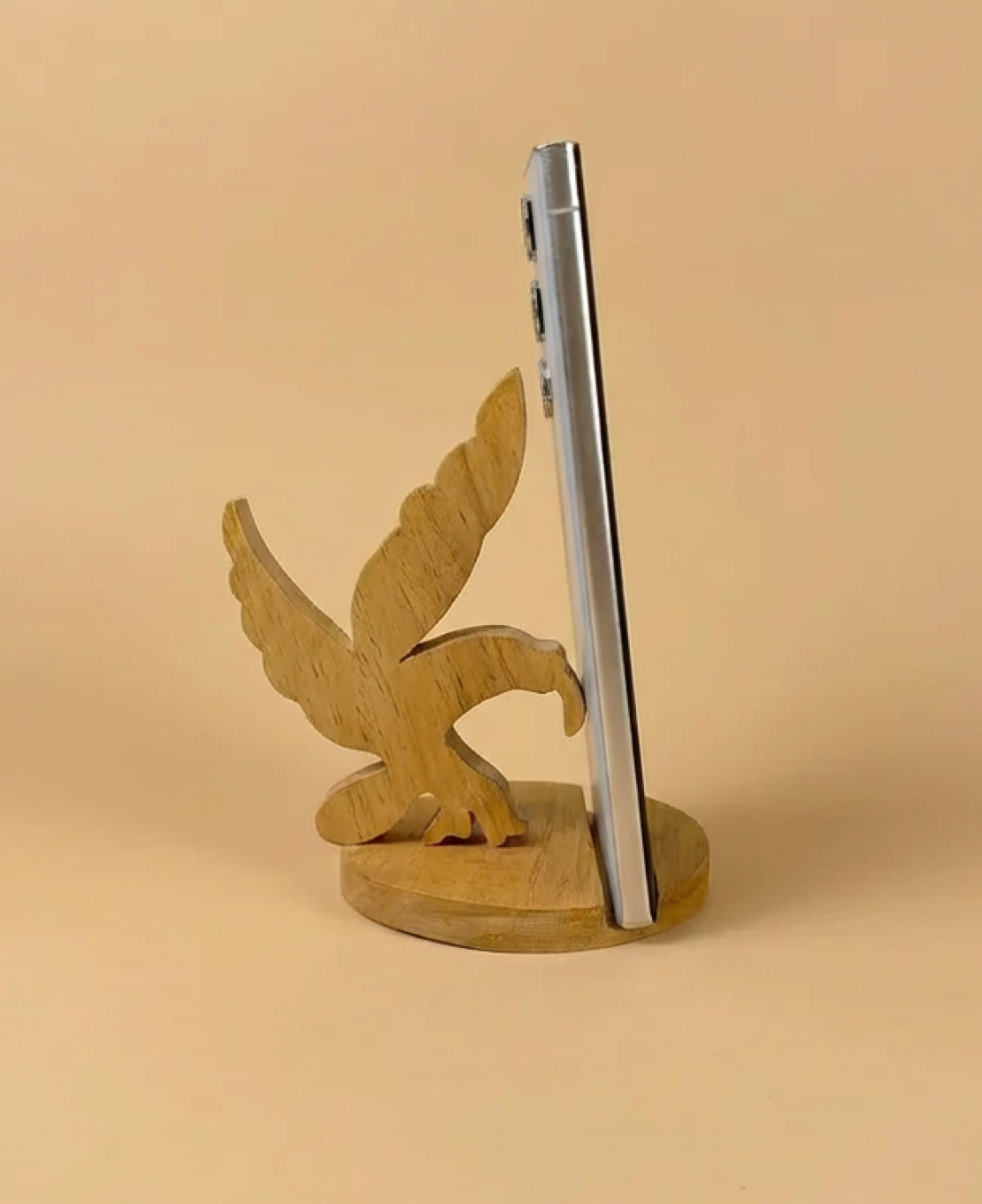 A handcrafted wooden eagle phone stand that offers sturdy phone support with a bold, artistic design.